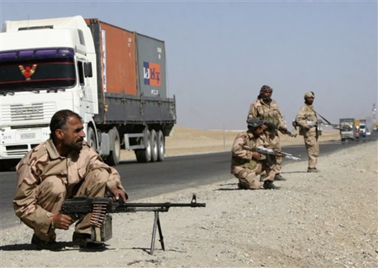 Private security contractors guard a part of a route as NATO supply trucks drive past in the province of Ghazni,  south-west of Kabul, Afghanistan, Wednesday, Oct. 27, 2010. Intense negotiations continued between Afghan President Hamid Karzai and the international community over the Afghan government's Dec. 17 deadline for ridding the nation of private security guards. (AP Photo/Rahmatullah Naikzad)